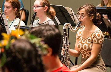 Three students playing instruments at the Summer Youth Music School